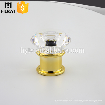 Botella de perfume de color dorado con tapa de flores